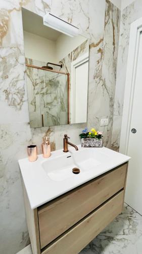 a bathroom with a sink and a mirror at Leila's home forever - casa vacanze in Bergamo
