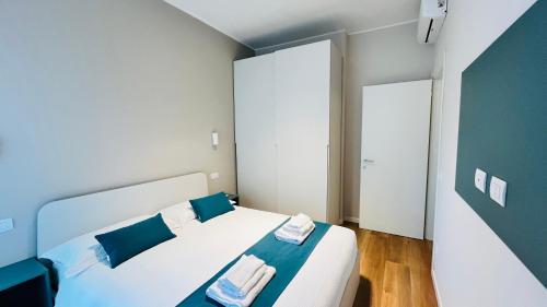 a bedroom with a bed with blue and white pillows at Leila's home forever - casa vacanze in Bergamo