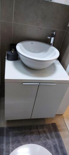 ein Badezimmer mit einem weißen Waschbecken auf einer Ablage in der Unterkunft OldTown Studio in Bukarest