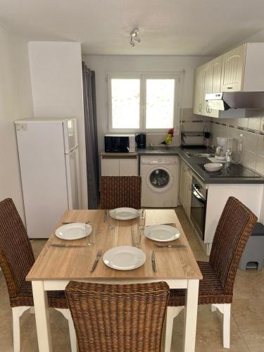 Il comprend une cuisine avec une table et des chaises en bois ainsi qu'une cuisine équipée d'un réfrigérateur. dans l'établissement Celle centre village proche therme, à Amélie-les-Bains-Palalda