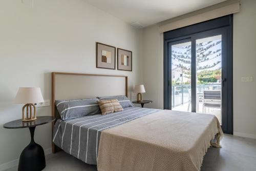 a bedroom with a bed and a sliding glass door at Luxury Apartment in Mil Palmeras in Dehesa de Campoamor