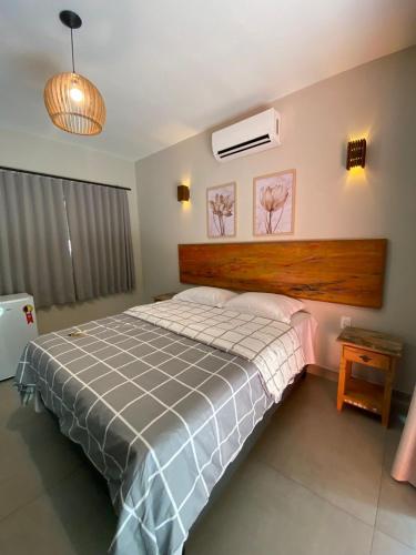 a bedroom with a large bed with a wooden headboard at Pousada Cigarras da Serra in Serra do Cipo