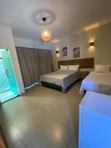 a hotel room with two beds and a light at Pousada Cigarras da Serra in Serra do Cipo