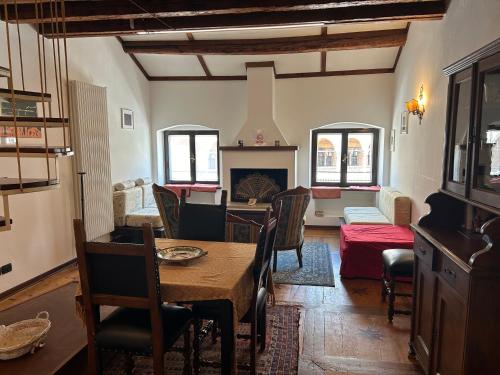 Una sala de estar con una mesa y una chimenea. en Appartamento delle Erbe, en Padua