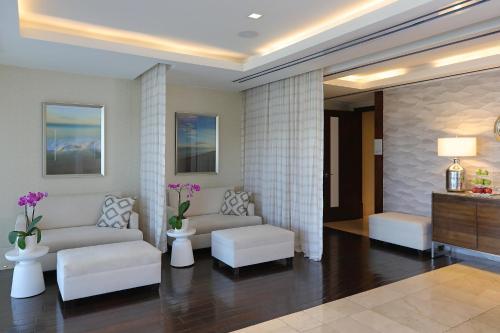 a living room with white couches and tables and flowers at InterContinental Real Santo Domingo by IHG in Santo Domingo