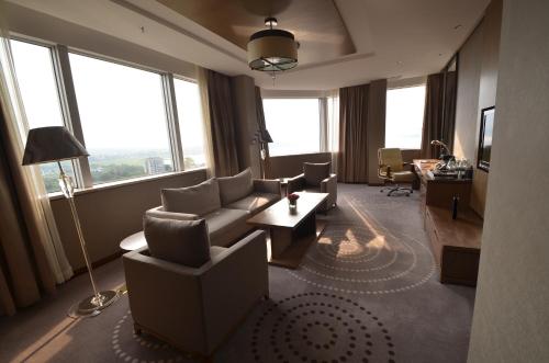 a living room with a couch and chairs and windows at Fleuve Congo Hotel By Blazon Hotels in Kinshasa