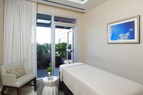 a bedroom with a bed and a chair and a window at InterContinental Real Santo Domingo by IHG in Santo Domingo