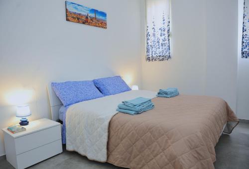 een slaapkamer met een bed met blauwe kussens bij La Dimora In Blu in Bologna