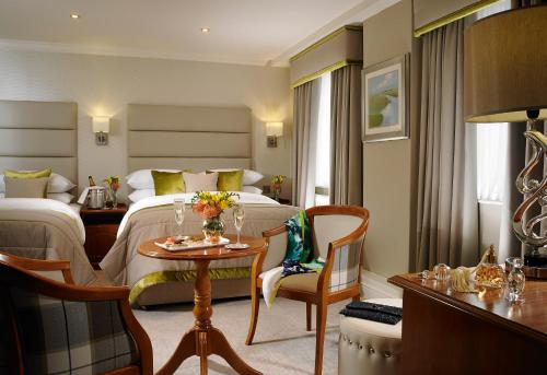 a hotel room with a table and chairs at Buswells Hotel in Dublin