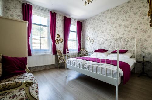 a bedroom with a white bed and pink curtains at Hotel Victoria in Schlangenbad