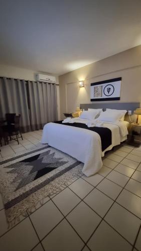 a large bedroom with a large bed with white sheets at Palace Hotel Três Poderes in Frutal