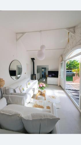 a living room with white couches and a table at Bord de rivière chez Anne in Sainte-Gemme-Moronval