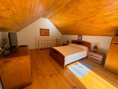 a bedroom with a bed and a flat screen tv at Casa do Batista in Seixal
