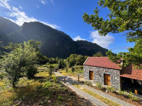 a stone house with a mountain in the background at Casa do Batista in Seixal