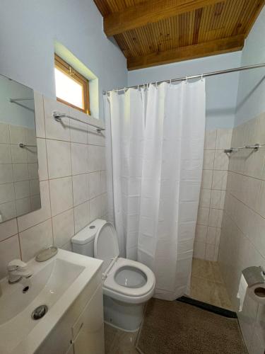 a bathroom with a white toilet and a sink at Casa do Batista in Seixal