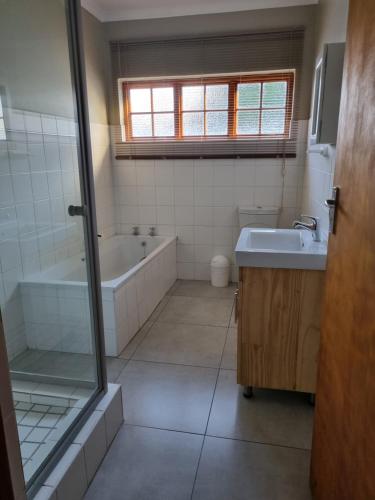 a bathroom with a tub and a sink at The Cottage in Cradock