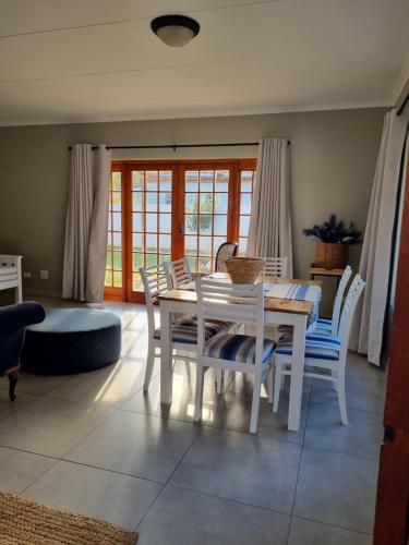 una sala da pranzo con tavolo e sedie bianchi di The Cottage a Cradock
