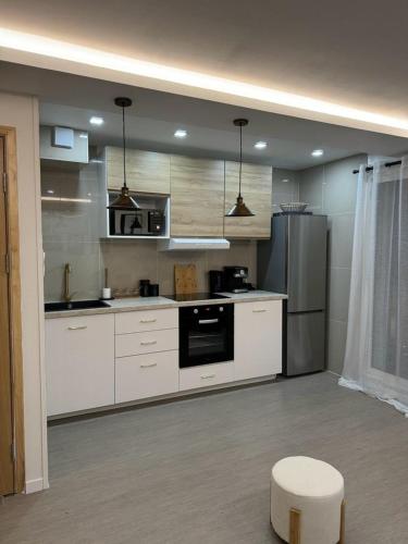 une cuisine avec des armoires blanches et un four à plaques de cuisson dans l'établissement APPARTEMENt COSY, à Nice