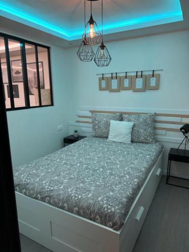 - une chambre avec un grand lit et un éclairage bleu dans l'établissement APPARTEMENt COSY, à Nice