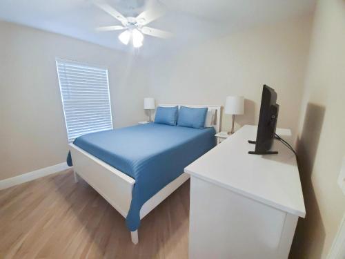 une chambre avec un lit et un bureau avec une télévision dans l'établissement The Cape Escape, à Cape Coral
