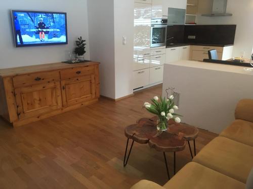 a living room with a kitchen and a table with flowers on it at Haus Salner in Sautens