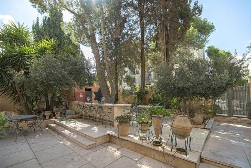 a patio with tables and chairs and potted plants at אחוזת קסם in Yerushalayim