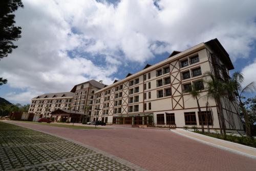 a large white building on a cobblestone street at Vista Azul Apart Hotel - Vista Pedra Azul in Pedra Azul