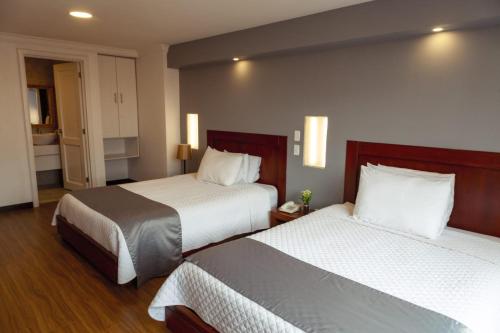une chambre d'hôtel avec deux lits avec des draps blancs dans l'établissement SÁ Hotel, à Cuenca