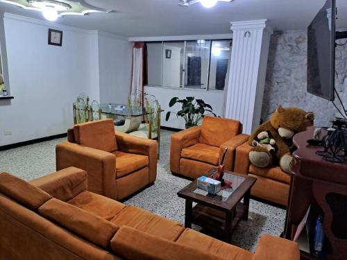a living room with couches and chairs and a teddy bear at APARTAMENTO en MIRAFLORES in El Peñón