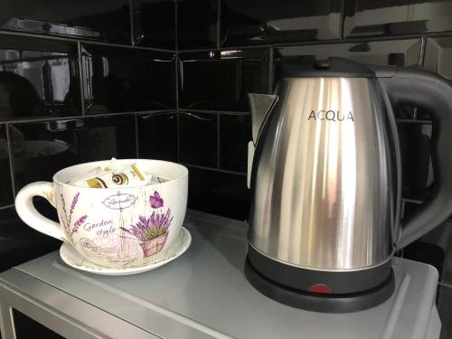 a tea kettle and a cup on a counter at Suite In City Center in Tirana
