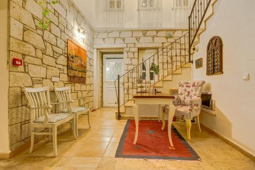 a room with a table and chairs and a stone wall at AlaNarin Konak in Alacati
