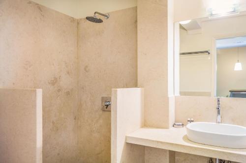 a bathroom with a sink and a mirror at Armonia Bay Hotel in Kokkari