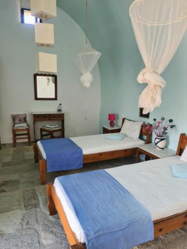 una habitación con tres camas y una mesa y una silla en Maisonnette Flo Mitata, en Mitáta