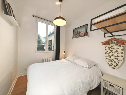 une chambre avec un lit blanc et une fenêtre dans l'établissement Cozy - Marché aux Puces de Saint-Ouen, à Saint-Ouen