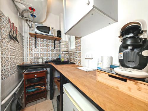 - une cuisine avec un comptoir et un four micro-ondes dans l'établissement Cozy - Marché aux Puces de Saint-Ouen, à Saint-Ouen
