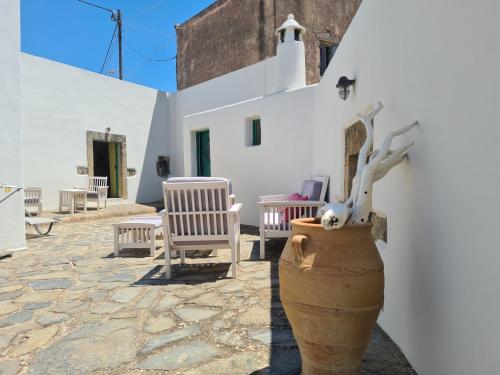 Un patio con sillas y un jarrón frente a un edificio. en Maisonnette Flo Mitata, en Mitáta