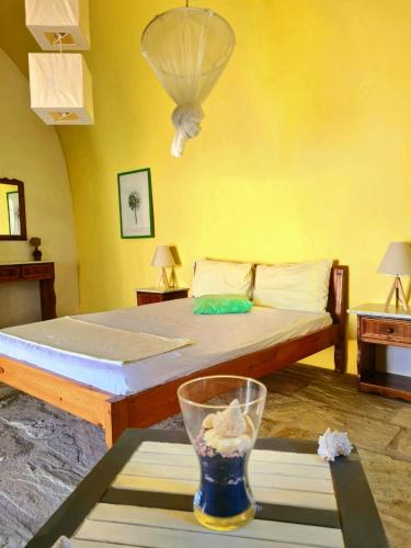 1 dormitorio con 1 cama y un jarrón sobre una mesa en Maisonnette Flo Mitata, en Mitáta