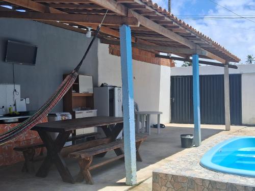 a patio with a hammock and a table and a tv at Casa temporada Barra de Jequia-Al in Jequia da Praia