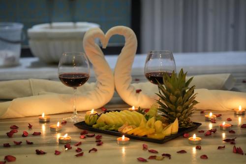 a table with two glasses of wine and a plate of food at Snowflake Dag Hotel & SPA in Sarıkamıs