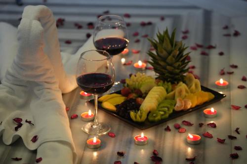 a table with a plate of food and two glasses of wine at Snowflake Dag Hotel & SPA in Sarıkamıs