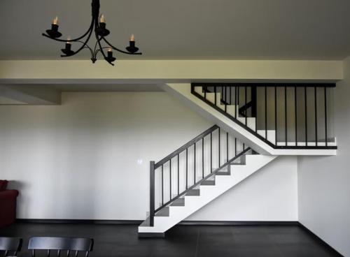a staircase in a building with chairs and a chandelier at Siedlisko na Agatowej w Rudnie in Rudno