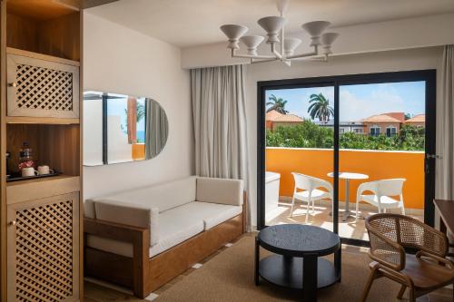 una sala de estar con un sofá y una mesa en El Beso Adults Only at Ocean Coral & Turquesa All Inclusive, en Puerto Morelos