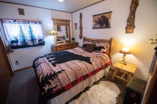 a bedroom with a bed and a table with a lamp at Black bear cabin with blow up hot tub in Necedah
