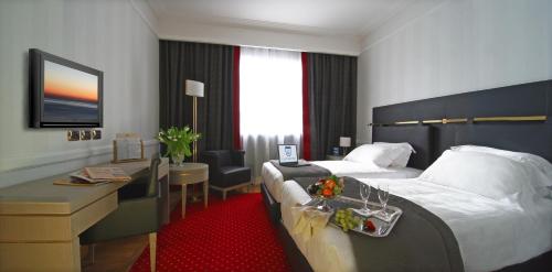 a hotel room with a bed and a desk at Grand Hotel Duca Di Mantova in Sesto San Giovanni