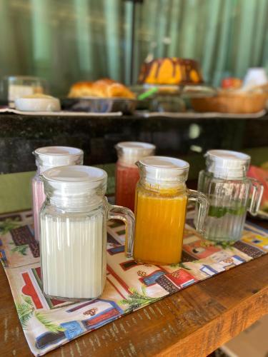 a tray with four jars of honey on a table at Pousada Cigarras da Serra in Serra do Cipo