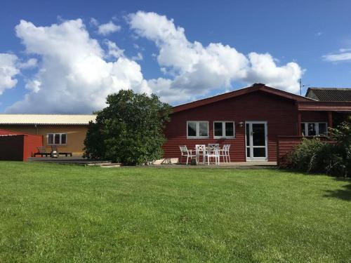 a red house with a lawn in front of it at LANDSTED nær HAV og BY - aktiv og rekreativ ferie in Ebeltoft