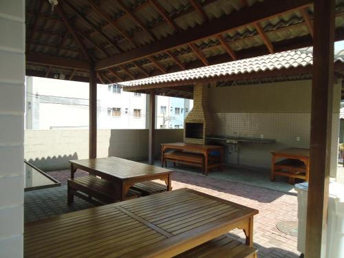 a patio with benches and a table and a fireplace at Apartamento Aconchegante Porto Real Resort Mangaratiba in Mangaratiba