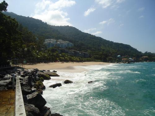 a view of a beach with rocks and the ocean at Apartamento Aconchegante Porto Real Resort Mangaratiba in Mangaratiba