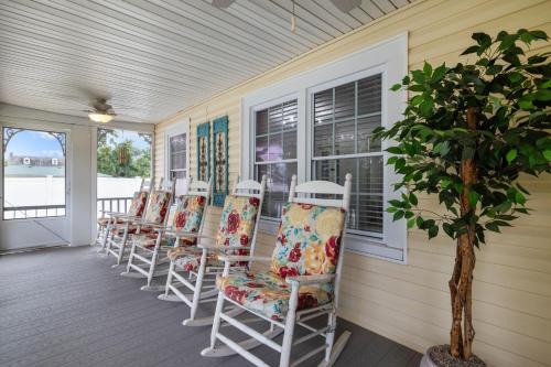 a row of chairs sitting on a porch at Imperial Porch Haven Cozy Fire Pit Fenced Yard in Imperial