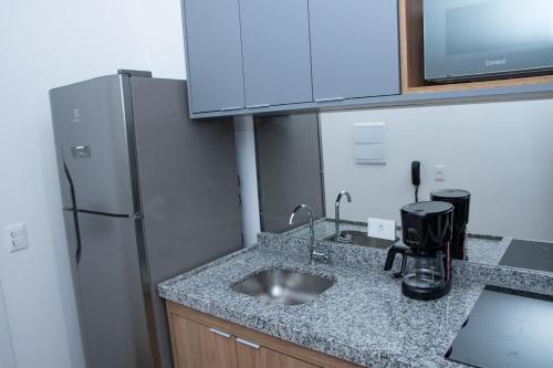 a kitchen with a sink and a refrigerator at ST Studios Vila Mariana by Housi in Sao Paulo